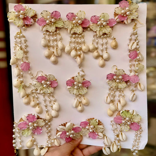 Set of decorative earrings on a white card held by a hand.